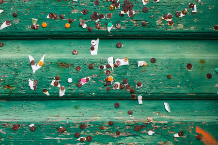 texture of green wood planks with small sheets of papers and old metal rusty pinsの写真素材