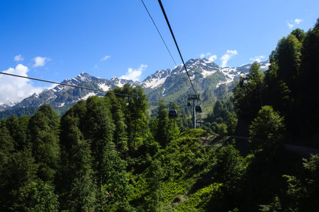 ropeway cabins in caucasus mountains covered with forest and snowの写真素材
