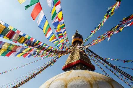 colorful praying flags and buddhist stupa in sunlight in nepalの写真素材