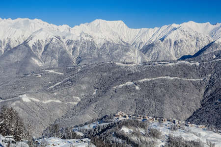 snowy mountain ridge and group of the hotels in Rosa Khutor ski resort Sochiの写真素材