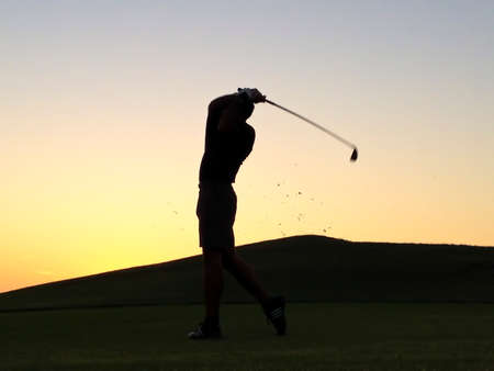 silhouette of a man playing golfの写真素材