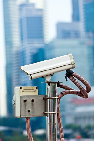 CCTV surveillance camera in Singapore with skyscapers in backgroundの写真素材