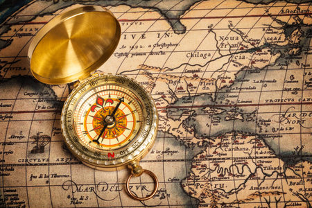 Old vintage retro golden compass on ancient mapの写真素材