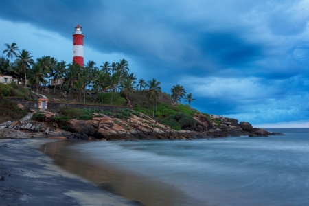Gathering storm on beach and Kovalam (Vizhinjam) lighthouse on stormy sunset. Kerala, Indiaの写真素材