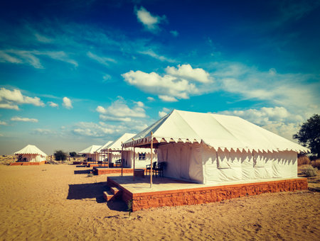 Vintage retro hipster style travel image of luxury tents in desert. Jaisalmer, Rajasthan, Indiaのeditorial素材
