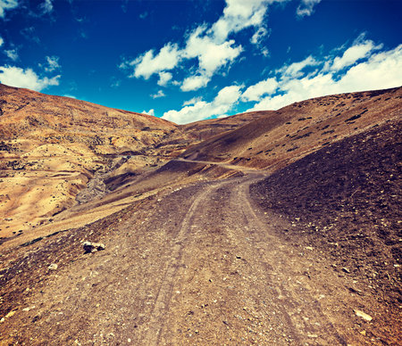 Vintage retro effect filtered hipster style travel image of dirt road in mountains (Himalayas). Spiti Valley,  Himachal Pradesh, Indiaの写真素材