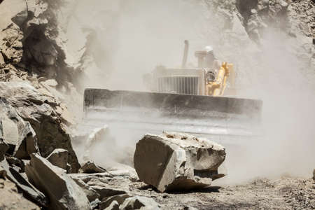 Bulldozer cleaning landslide on road in Himalayasの写真素材