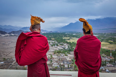 THIKSEY, INDIA - SEPTEMBER 4, 2011: Two Tibetan Buddhist monks blowing conches during morning pooja, Thiksey gompa, Ladakh, Indiaのeditorial素材