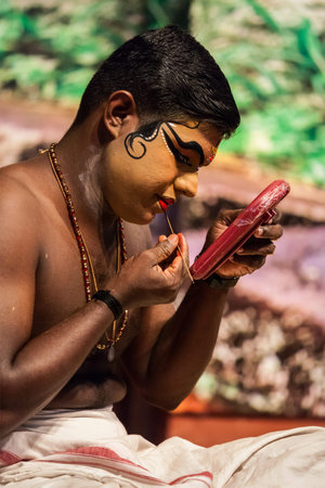 KOCHI, INDIA - FEBRUARY 24, 2013: Unidentified Kathakali exponent preparing for performance by applying face make-up. Kathakali is the classical dance form of Keralaのeditorial素材