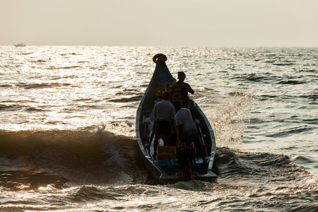 CHENNAI, INDIA - FEBRUARY 10, 2013: Group of Indian fishermen going into the sea on boat for fishing on sunriseのeditorial素材