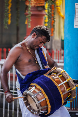 KOCHI, INDIA - FEBRUARY 24, 2013: Indian man playing drum during temple festival in Keralaのeditorial素材