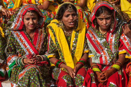 PUSHKAR, INDIA - NOVEMBER 21, 2012: Unidentified Rajasthani girls in traditional outfits prepare for...