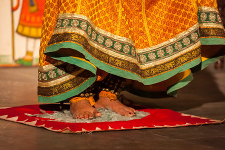 UDAIPUR, INDIA - NOVEMBER 24: Bhavai performance - folk dance of Rajasthan Performer balances number of pots as she dance on broken glass. Legs close up. November 24, 2012 in Udaipur, Rajasthan, Indiaのeditorial素材