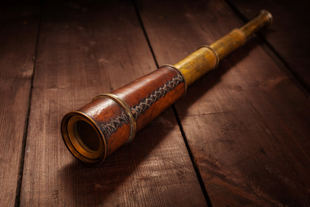 Vintage retro spyglass on wooden backgroundの写真素材