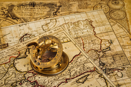 Travel geography navigation concept background - old vintage retro compass with sundial on ancient world mapの写真素材