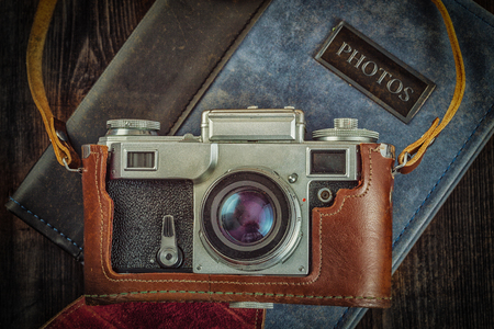 Photography concept  background - old retro vintage camera on photo album on grunge wooden textureの素材 [FY31046102081]