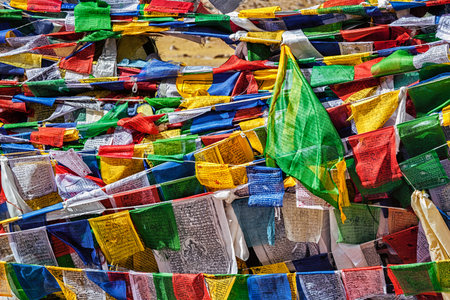 Buddhist prayer flags lungta with mantra Om mani padme hum in tibetan language on Namshang La pass...