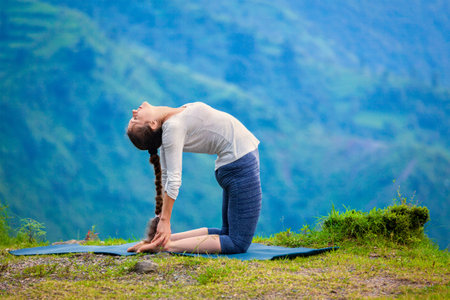 Yoga - outdoors  young beautiful slender woman yoga instructor doing camel pose Ustrasana asana...