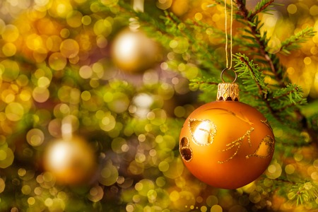 Christmas celebration holiday background - christmas-tree decoration bauble on decorated Christmas tree with defocused blurred lights bokeh and copyspalceの写真素材