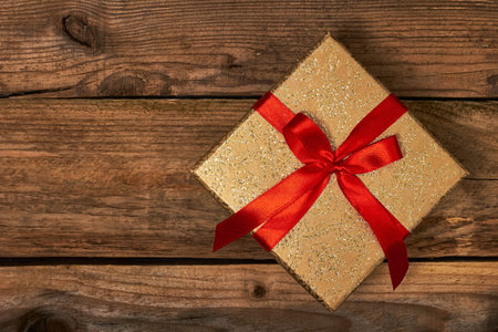 Gift present birthday Christmas concept - gift box with red ribbon on wooden background