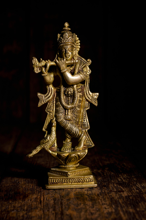 Krishna statue on wooden backgroundの写真素材