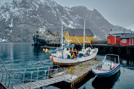Fishermen and fishing boat on pier in Nusfjord fishing village,のeditorial素材