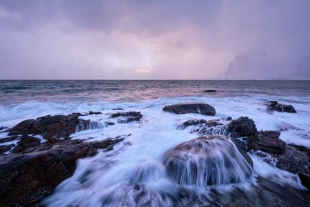 Coast of Norwegian sea on rocky coast in fjord on sunsetの写真素材
