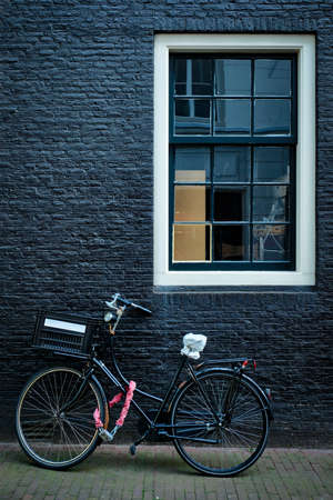 Bicycle near wall of old house in Amsterdam streetの写真素材