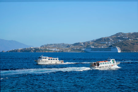 Boat and cruise liner is Aegean sea. Chora, Mykonos island, Greece