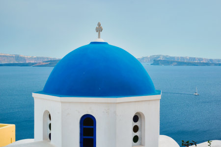 Famous view from viewpoint of Santorini Oia village with blue dome of greek orthodox Christian churchの写真素材