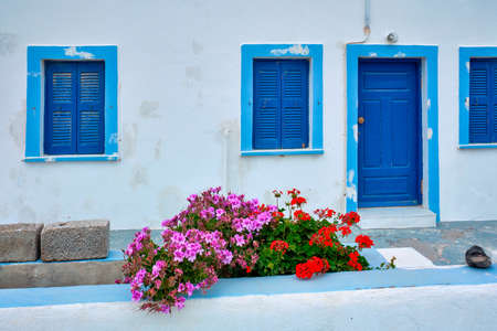Greek white house with blue door and window blinds Oia village on Santorini island in Greeceの写真素材