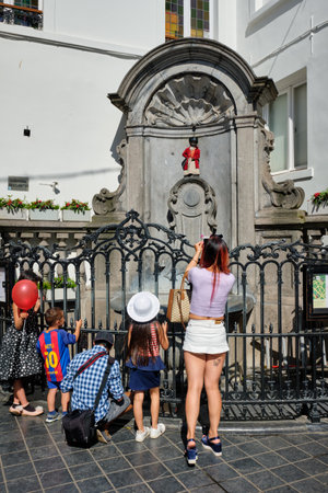 Tourist taking pictures in front of famous tourist attraction of Brussels - Manneken Pis statueのeditorial素材