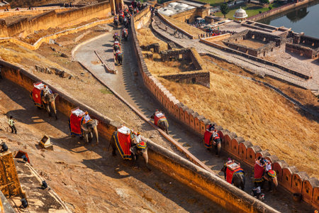 AMER, INDIA - NOVEMBER 18, 2012: Tourists riding elephants on ascend to Amer (Amber) fort,...