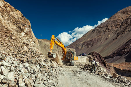 LADAKH, INDIA - SEPTEMBER 10, 2011: Excavator cleaning road after landslide in Himalayas. Ladakh, Jammu and Kashmir, Indiaのeditorial素材