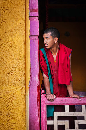THIKSEY, INDIA - SEPTEMBER 13, 2012: Young Buddhist monk standing in doorway of of Thiksey gompa, Ladakh, Indiaのeditorial素材