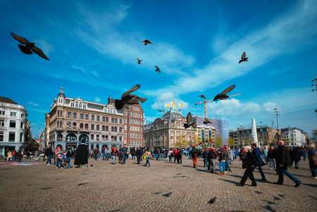 Amsterdam, Netherlands - May 7, 2017: Dam square with crowd and flying pigeonsのeditorial素材
