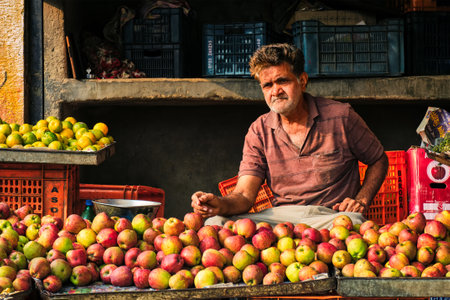 Jodhpur, India - November 14, 2019: Fruit seller in his shop selling apples in Sadar Market. Jodhpur, Rajasthan, Indiaのeditorial素材