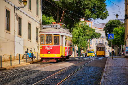 Lisbon, Portugal - August 26, 2022: Famous vintage yellow tram 28 in narrow streets of Alfama district in Lisbon, Portugal - symbol of Lisbon, famous popular travel destination and tourist attractionのeditorial素材