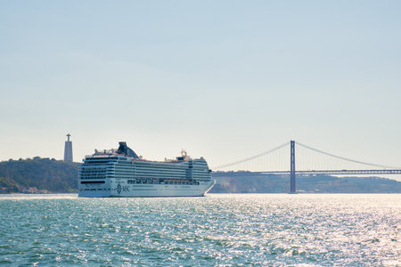 Lisbon, Portugal - August 31, 2022: MSC Orchestra cruise ship of Musica class in Tagus river with the 25 de Abril Bridge in the background. She could accommodate 2550 passengers in 1275 cabinsのeditorial素材