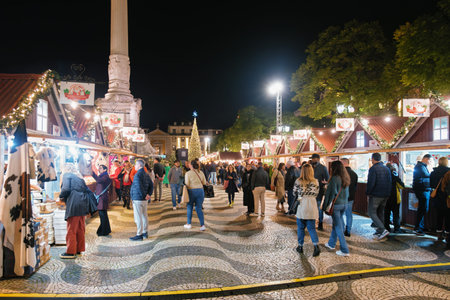 Lisbon, Portugal - December 9, 2022: Christmas market on Rossio square with people decorated for Christmas in the eveningのeditorial素材
