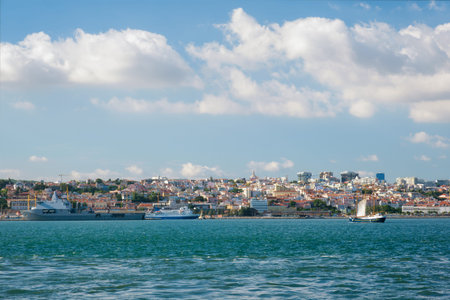 View of Tagus river with tourist boat and moored NATO warships in Lisbon, Portugal