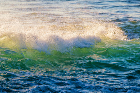 Breaking ocean wave on sunset backlit with sun. Fonte da Telha, Costa da Caparica, Portugal. Slow...
