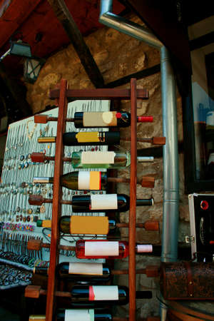 Red  and wite wine bottles stacked on wooden racks shot withの写真素材