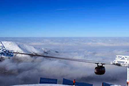 Ski lift climb up above the clouds clear dayの写真素材