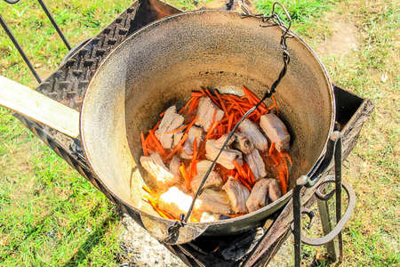 Tourist boiler with food standing on the grill over the fire. Focus on the pot.の写真素材