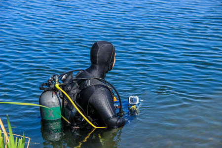 Scuba diver with full face mask entering lakeの写真素材