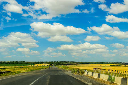 blue sky with white clouds over roadの写真素材