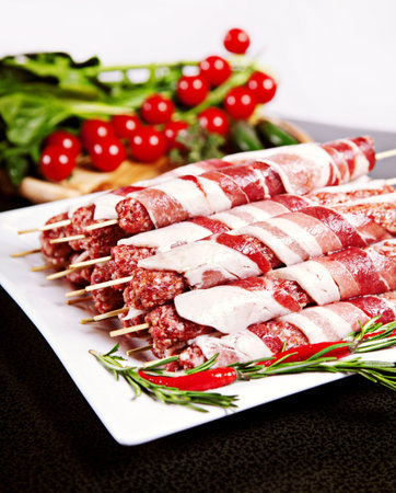 Raw kebab with chili, tomatos and lettuce served on plateの写真素材