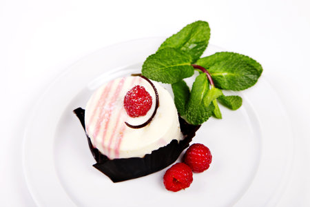 Small cake with rasberry and mint on white backgroundの写真素材