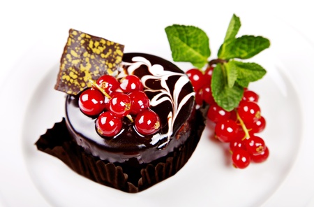Mini cake with chocolate, mint and berries on white backgroundの写真素材
